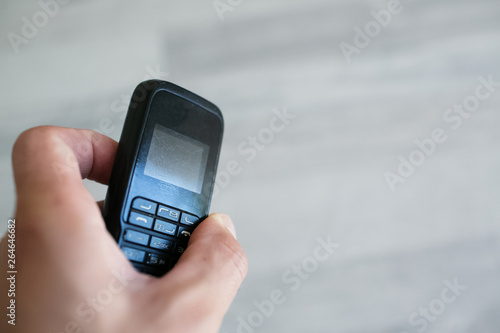 Close-up of man hand holding old black mobile phone