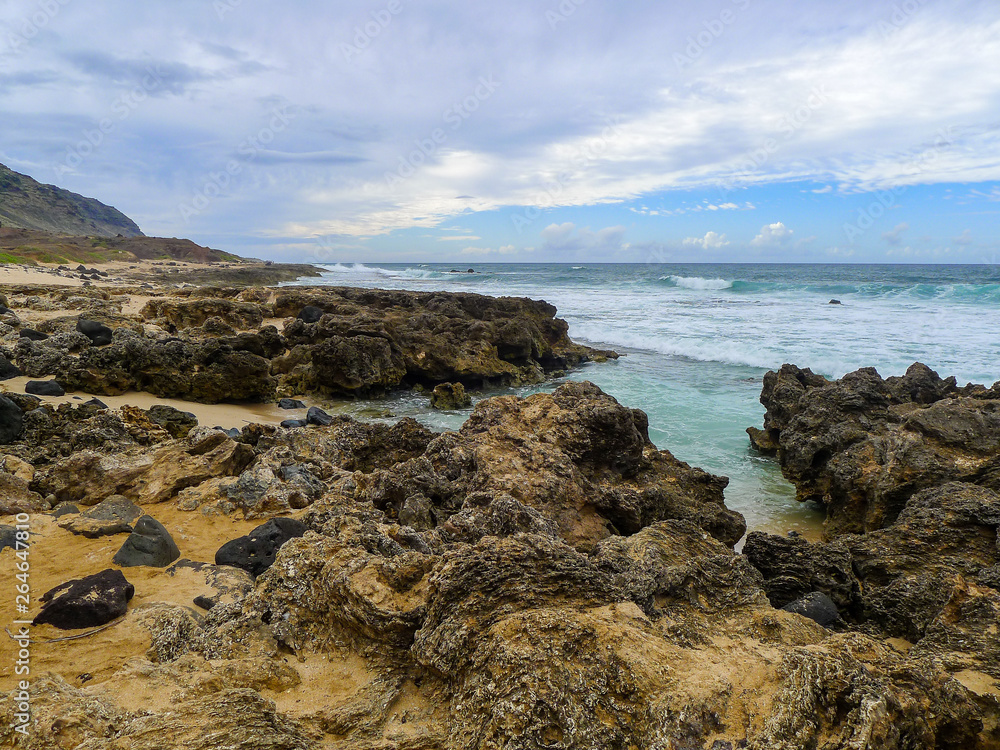 Coastline at the west side of Oahu, Hawaii with large rocks at the beach.