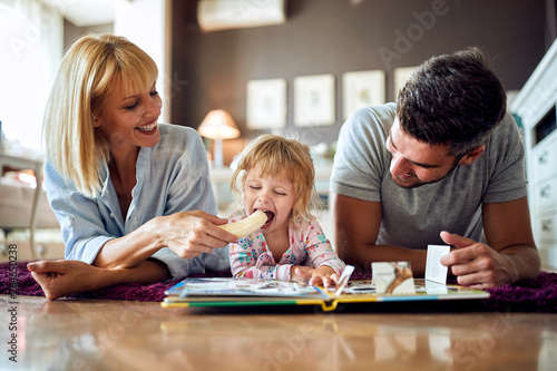 Female child with parents eating banana