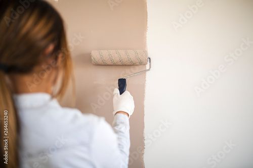 фотографія Close up of a woman painting wall with roller.