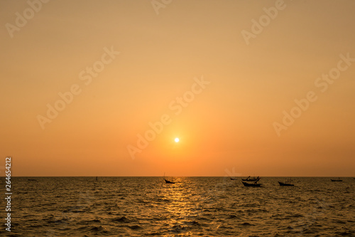 Bright sunset with large yellow sun under the sea surface. sunrise in the sea. Beautiful sunset above the sea. Tropical sunset on the beach. © kanpisut