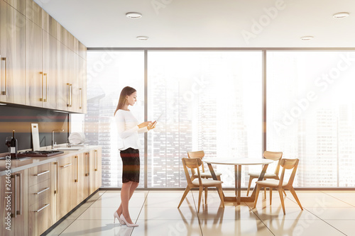 Blonde woman in panoramic kitchen