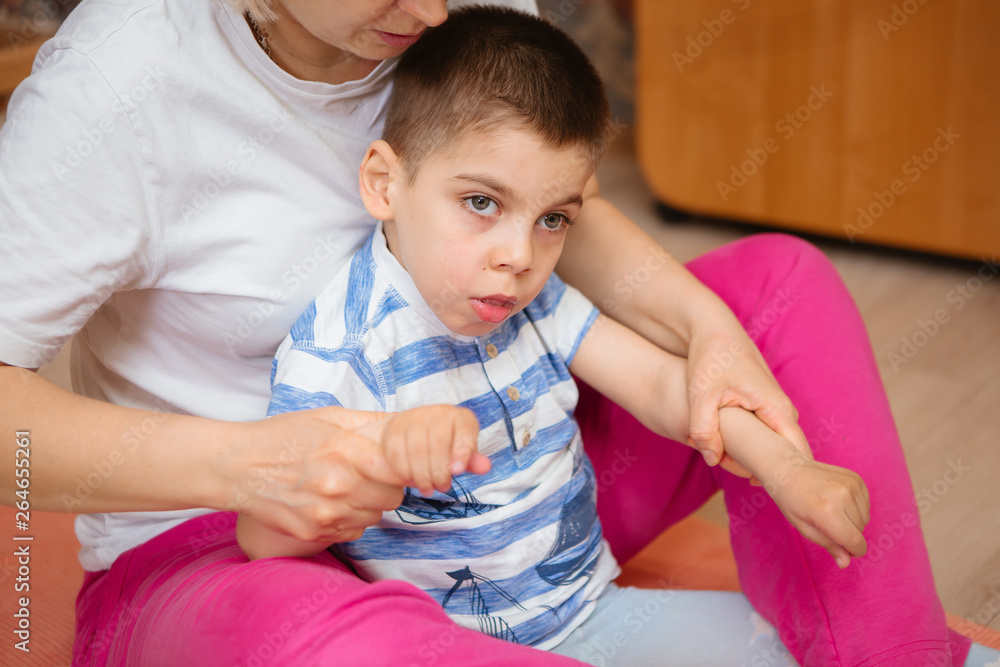 little kid with cerebral palsy has musculoskeletal therapy by doing