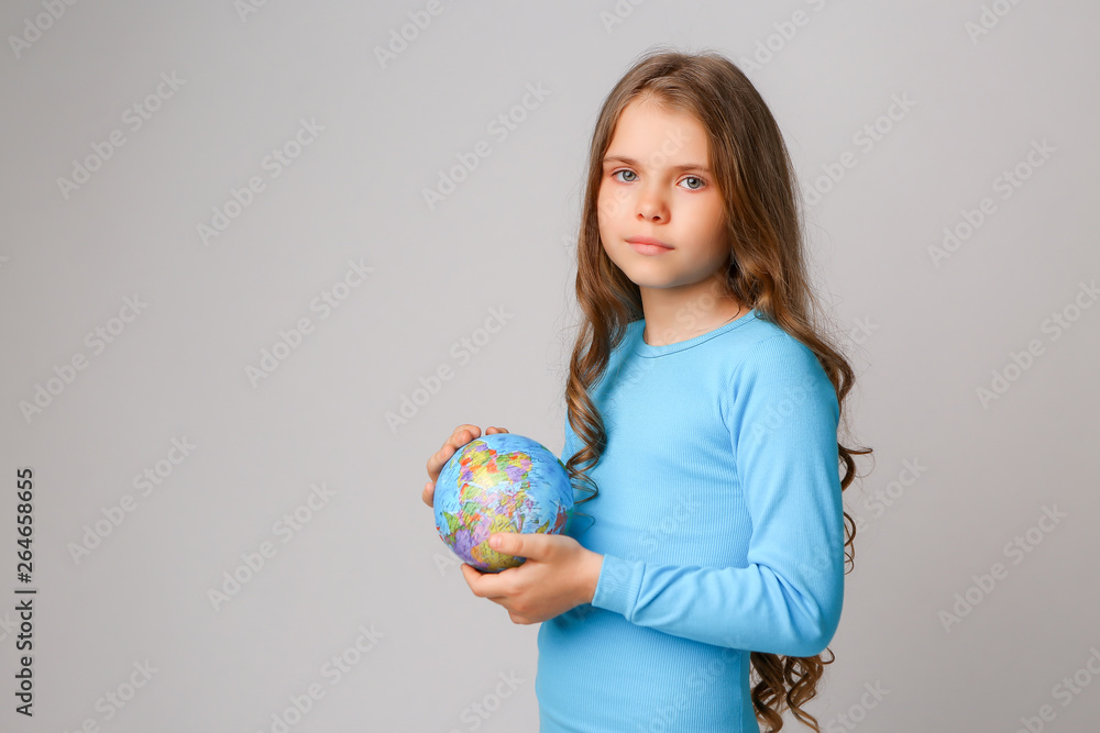 baby girl in blue dress holding globe, concept of environmental protection baby girl in blue dress holding globe, concept of environmental protection