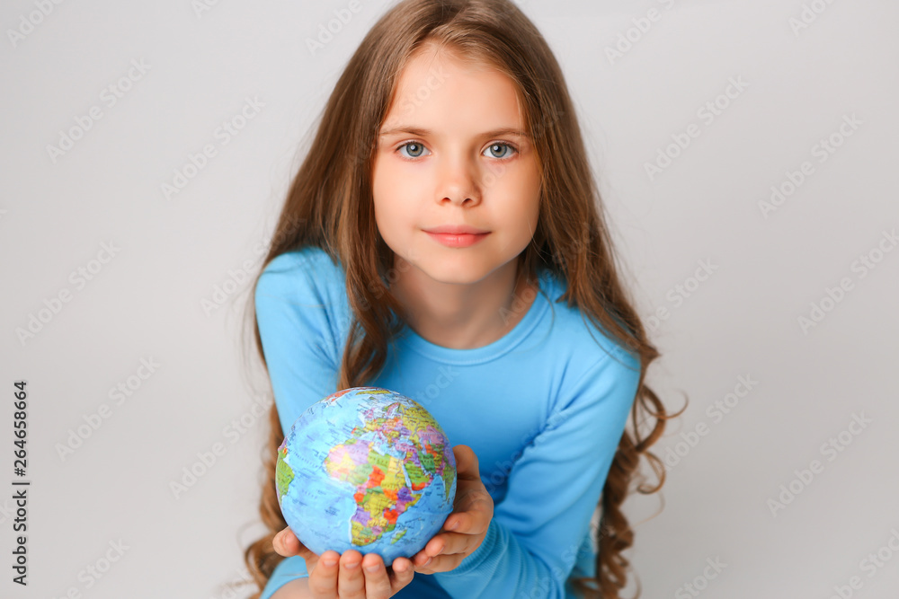 baby girl in blue dress holding globe, concept of environmental protection baby girl in blue dress holding globe, concept of environmental protection