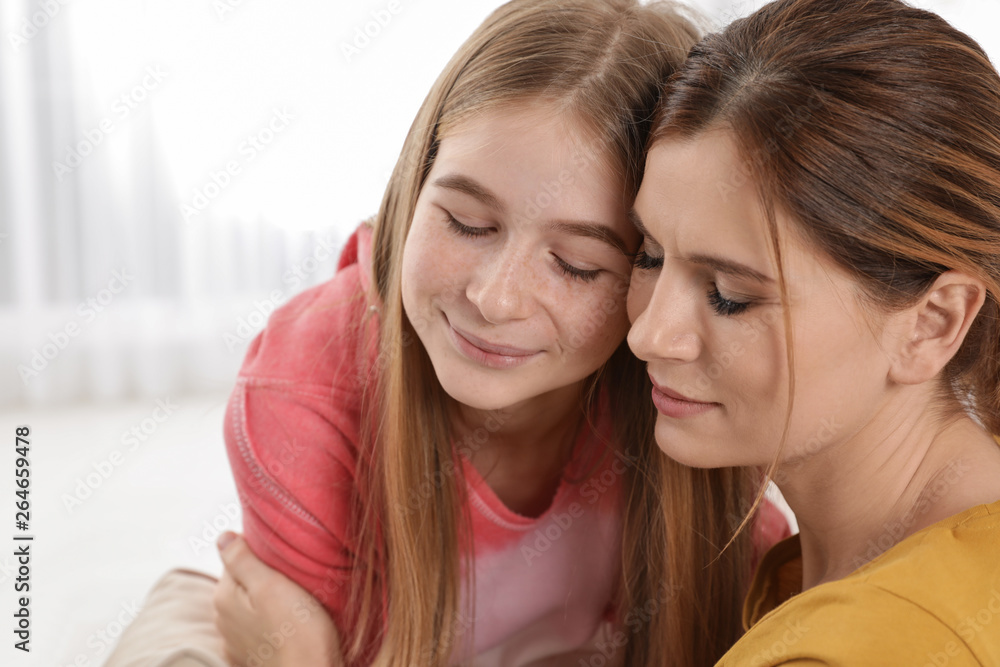 Happy mother hugging her teenager daughter at home Happy mother hugging her teenager daughter at home
