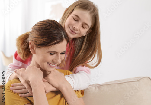 Teenager daughter hugging her mother at home