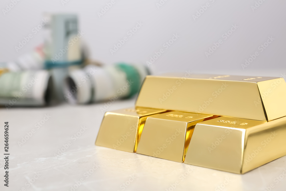 Shiny gold bars and dollar rolls on table, closeup. Space for text Shiny gold bars and dollar rolls on table, closeup. Space for text