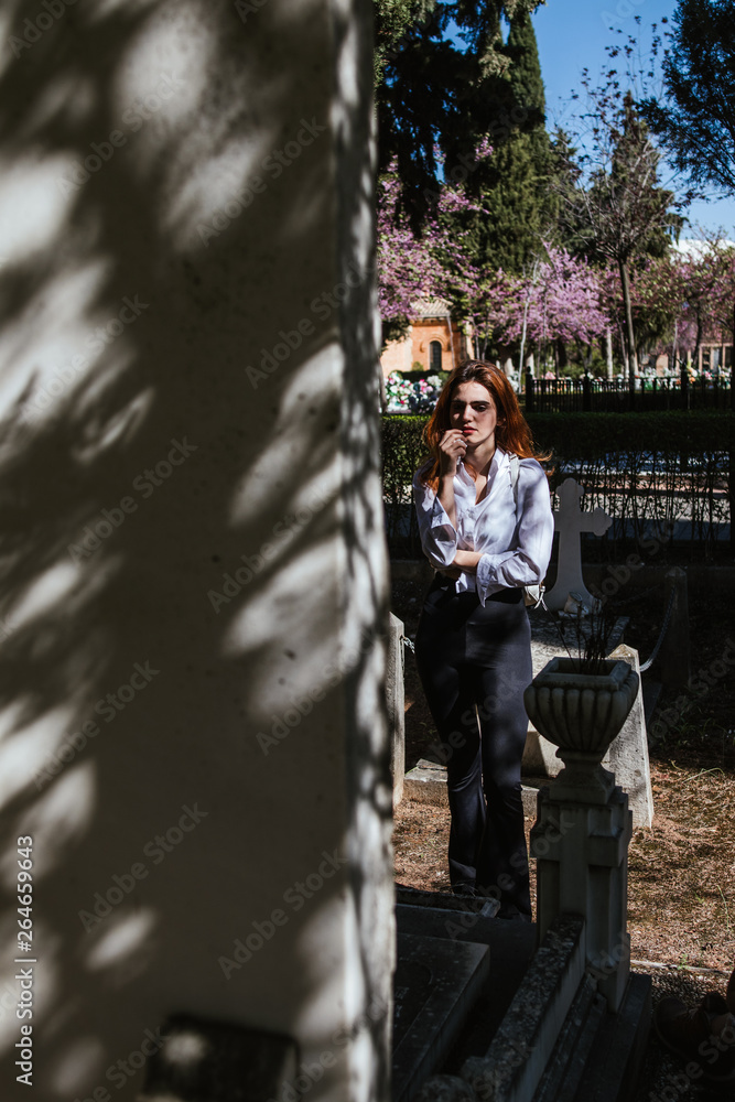 Woman crying in the graveyard by a deceased relative Woman crying in the graveyard by a deceased relative