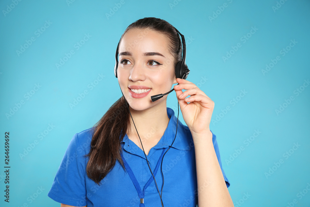 Portrait of technical support operator with headset on color background