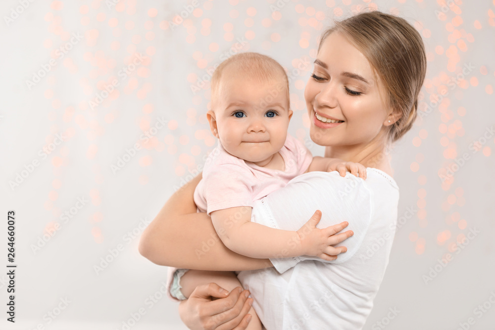 Portrait of happy mother with her baby against blurred lights Portrait of happy mother with her baby against blurred lights