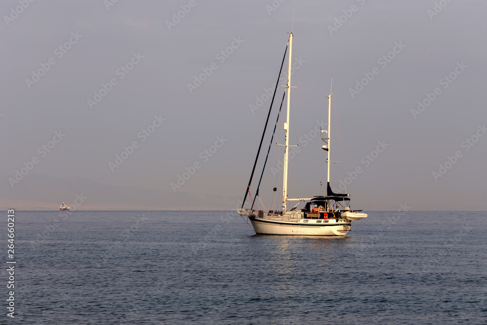 The yacht sails moored on the open sea