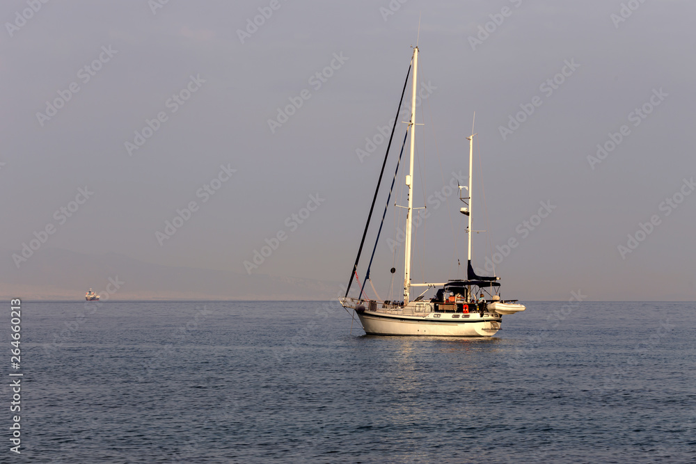 The yacht sails moored on the open sea The yacht sails moored on the open sea