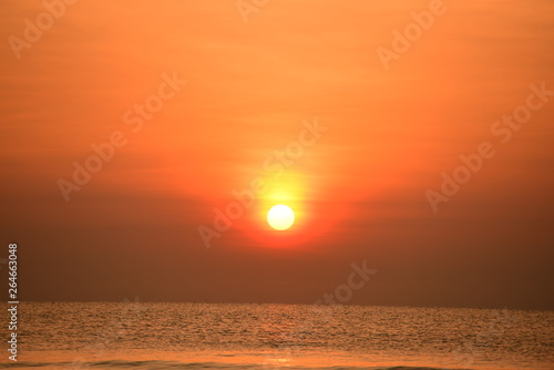 The rising sun view and the beach. Beautiful golden yellow sky and sun The view of the beach, the beach and the sun loungers are rising. Beautiful golden yellow sky and sun