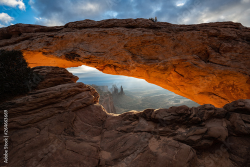 Mesa arch at sunrise from Canyonlands National Park near Moab Utah USA. The orange rim glow on the underside arch wall is courtesy of the rising sun.