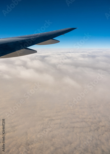 Aerial View from an Airplane. Flying above Clouds at Sunrise