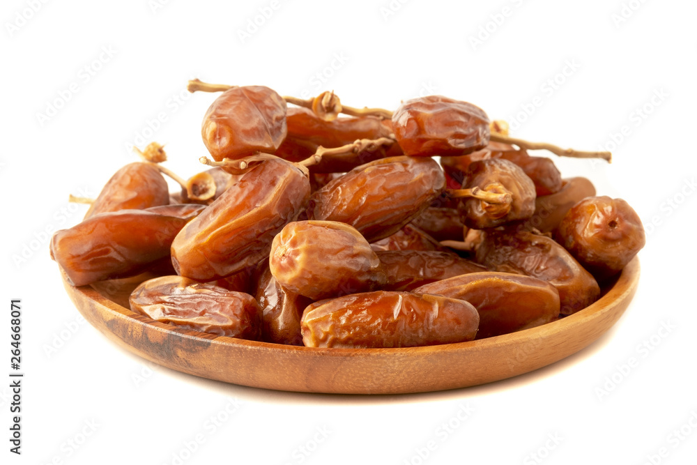 Close up of cluster dates plam. Fresh dates plam in wooden tray over white background.