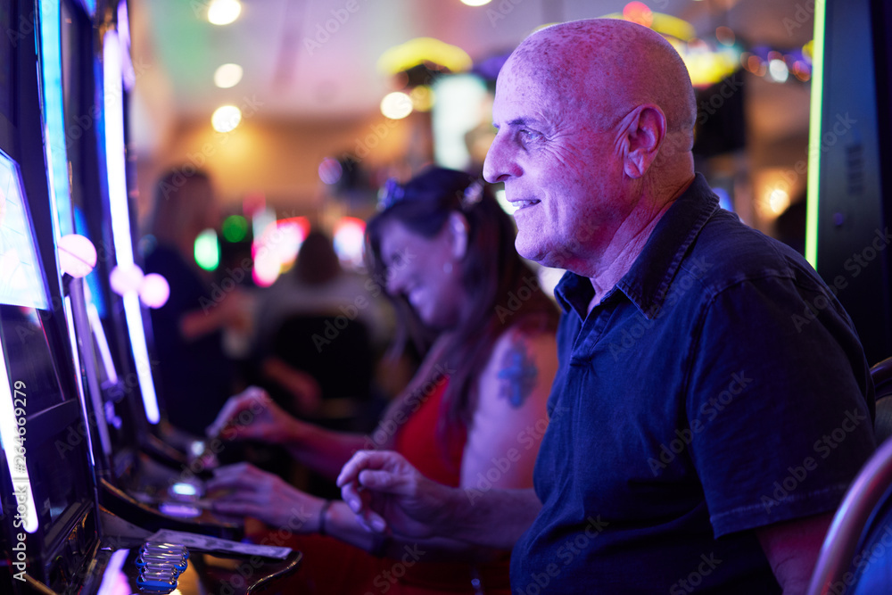 elderly tourist playing slot machines and gambling in casino elderly tourist playing slot machines and gambling in casino