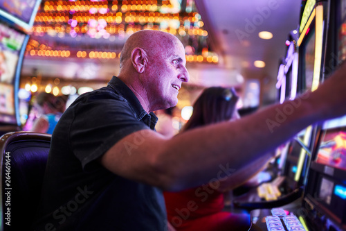 Cuadro en lienzo elderly tourist playing slot machines and gambling in casino