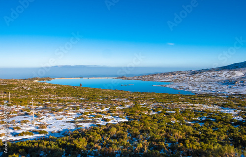 Mountain landscape with snow and a beautiful blue water Lagoon (Lagoa Comprida), Serra da Estrela, Portugal