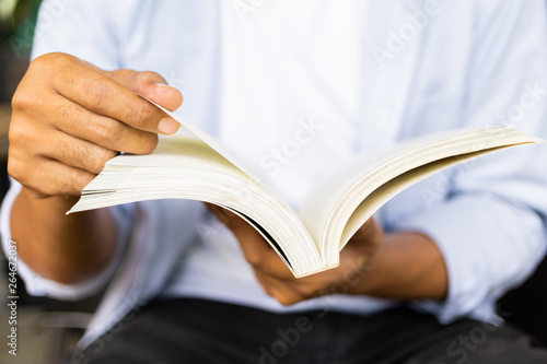 Hand young man opening book and reading book.