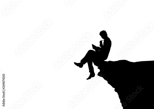 岩に座って勉強する男性のシルエット