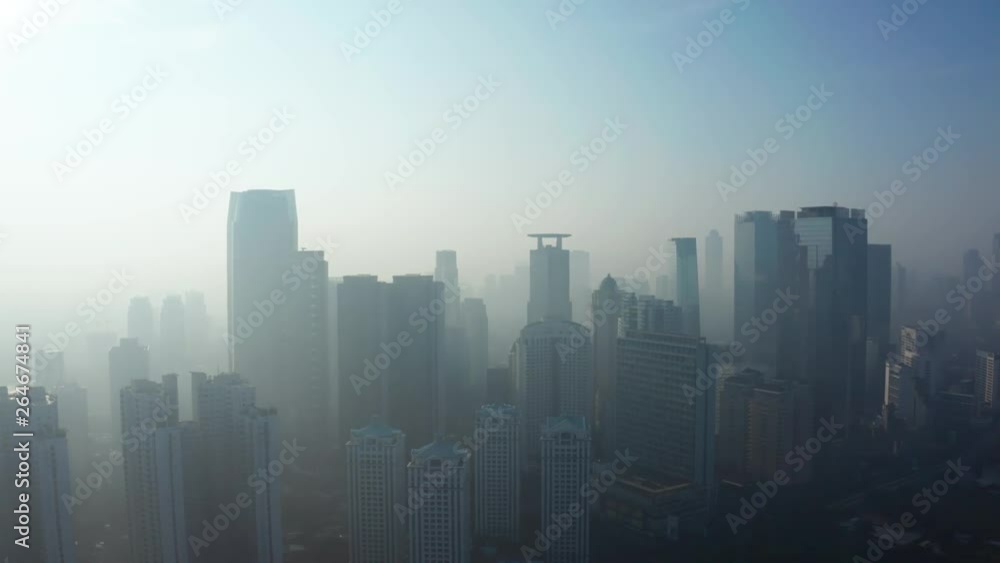 JAKARTA, Indonesia - April 25, 2019: Aerial scenery of Jakarta city with silhouette of skyscrapers behind fog on the morning. Shot in 4k resolution from a drone flying from left to right JAKARTA, Indonesia - April 25, 2019: Aerial scenery of Jakarta city with silhouette of skyscrapers behind fog on the morning. Shot in 4k resolution from a drone flying from left to right