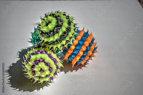 three colorful striped balls with spikes