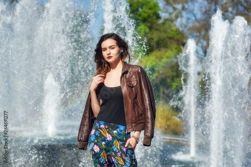 Young fashionable girl posing on the street of a European city .  Model with leather jacket