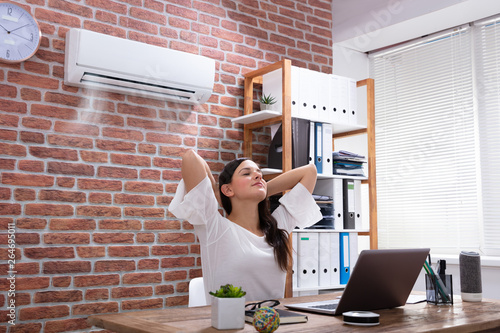 Businesswoman Enjoying The Cooling Of Air Conditioner photo