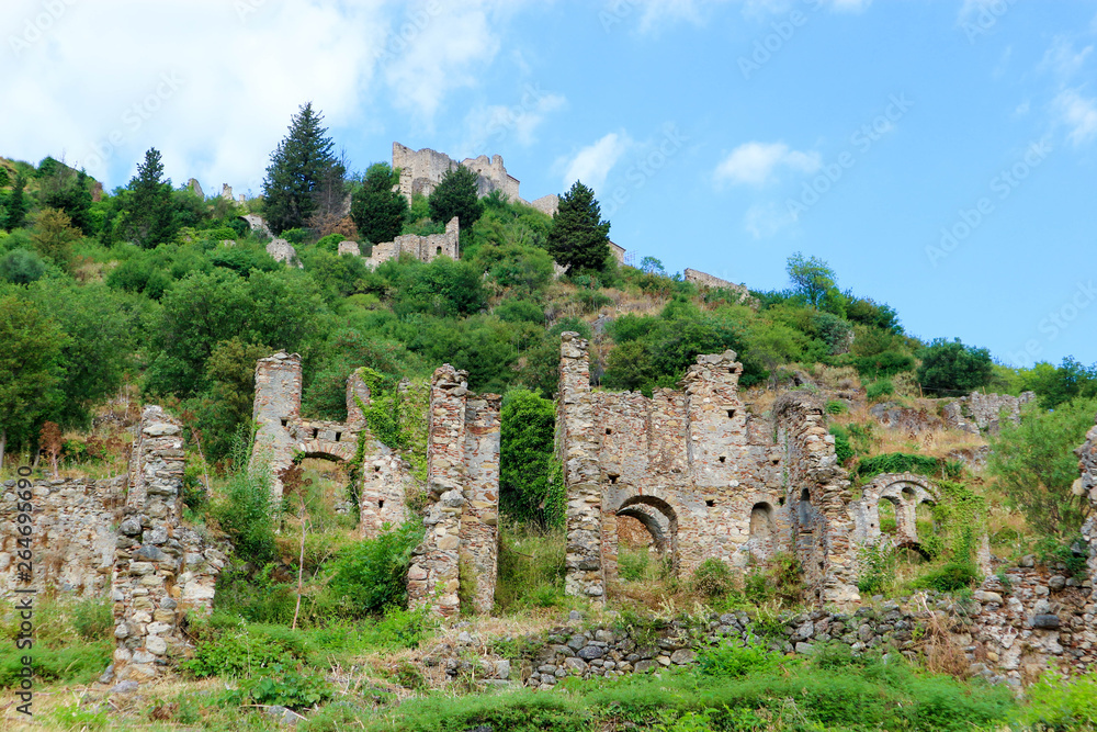Picturesque ruins of abandoned medieval town Mystras, Greece against blue summer sky