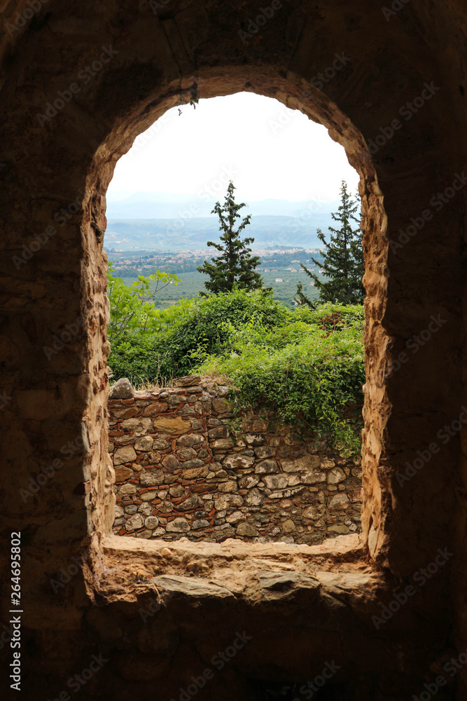 Arch window in the wall of the ruin of medieval house in abandoned city Mystras, Peloponnese, Greece