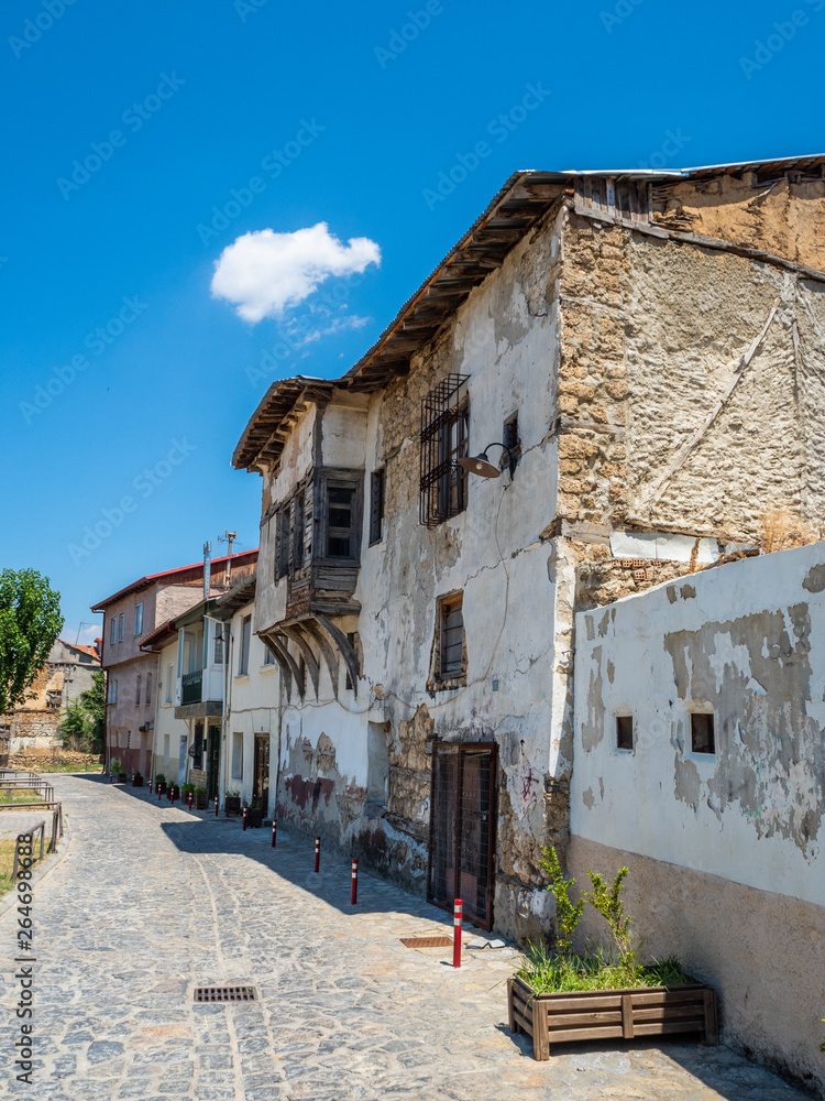 Old stone house with a wooden gate and windows on a narrow street in the city of Edessa, Greece
