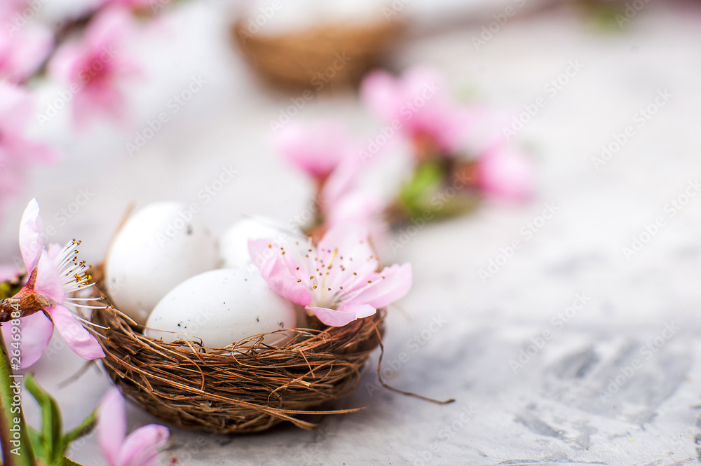 Spring blossom concept. Easter concept, eggs in a nest, flowering tree close-up and copy space. Pink natural texture of natural flowering tree. Easter eggs and branches of blossoming on an table. Top Spring blossom concept. Easter concept, eggs in a nest, flowering tree close-up and copy space. Pink natural texture of natural flowering tree. Easter eggs and branches of blossoming on an table. Top