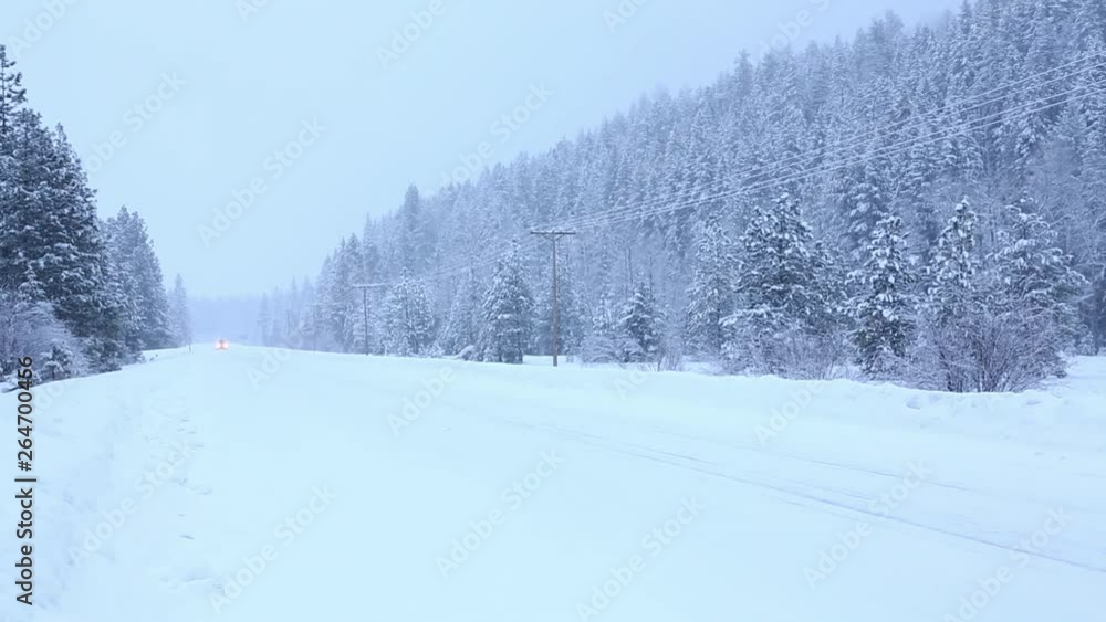 Vehicle car SUV with rooftop cargo box carrier driving on snowy country rural road in winter snow storm snowstorm HD video Vehicle car SUV with rooftop cargo box carrier driving on snowy country rural road in winter snow storm snowstorm HD video