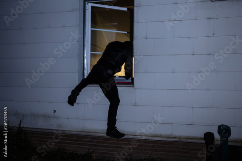 Burglar Entering In A House Through A Window photo