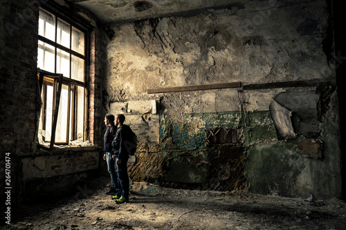 Portrait of two, young people standing in ruined, old factory. © bint87