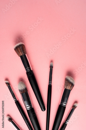 Creative concept beauty fashion photo of cosmetic product make up brushes kit on pink background.