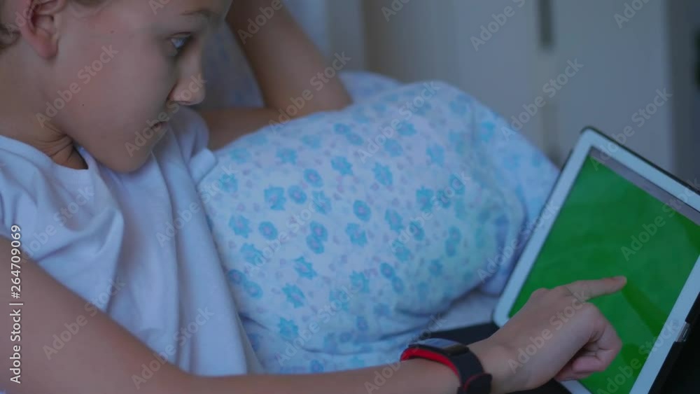 Screenager In House Teenager boy moving fingers, touching green screen of tablet, side view ...