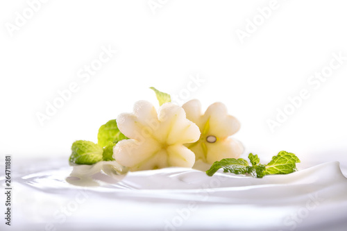 Plain yogurt with fresh flower shape apple on top in bowl isolated on white background