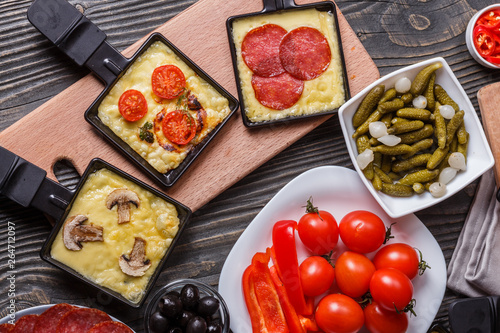 young woman is preparing a traditional Swiss cheese raclette