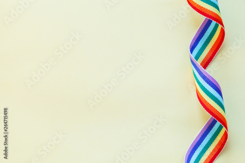 LGBT rainbow ribbon isolated on yellow background, copy space, top view, flat layout