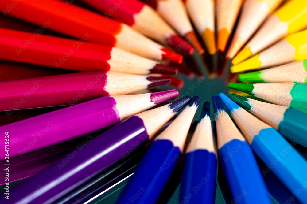 Many different colored pencils reflected on black Many different colored pencils reflected on black