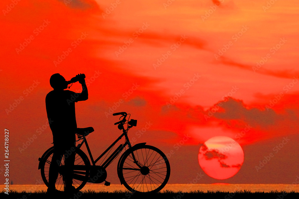 Fototapeta premium Silhouette man and bike relaxing on blurry sky background.