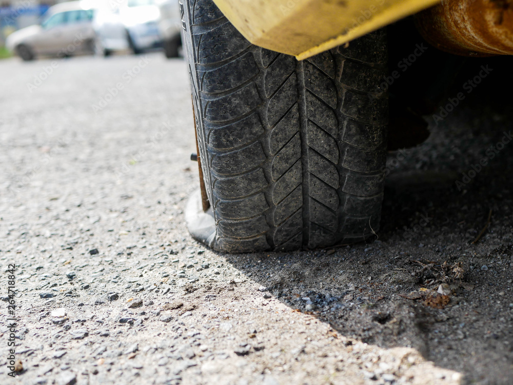 Flat tire on parking car, shallow depth of field, copy space. Flat tire on parking car, shallow depth of field, copy space.
