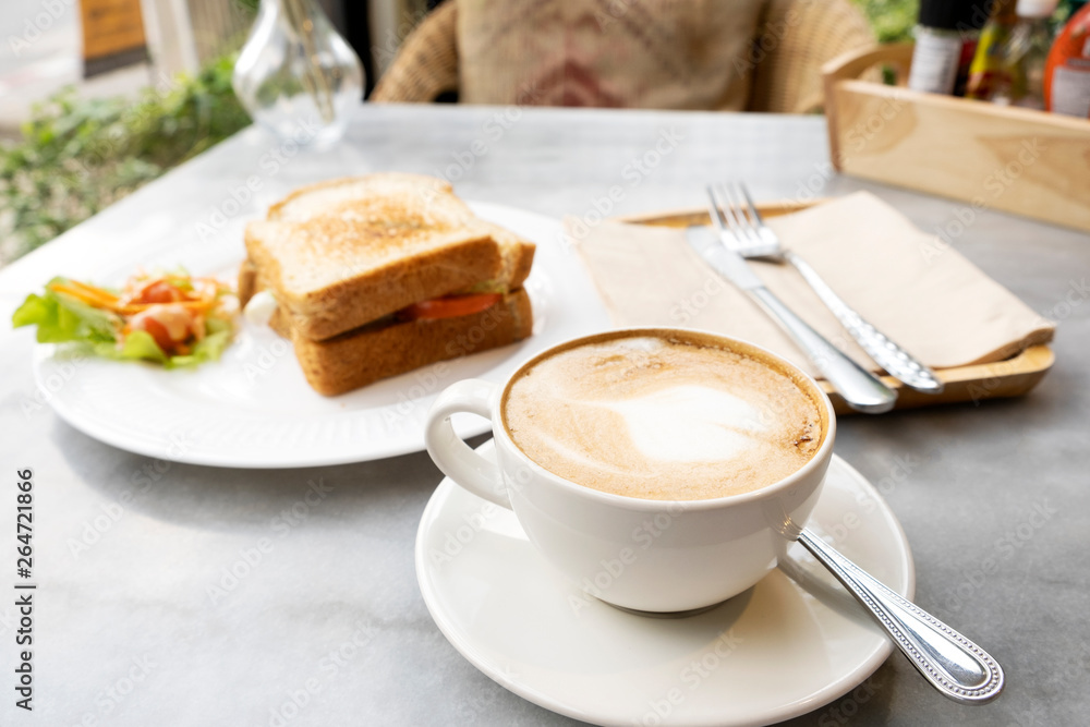 Hot latte coffee and sandwiches on the marble table Hot latte coffee and sandwiches on the marble table