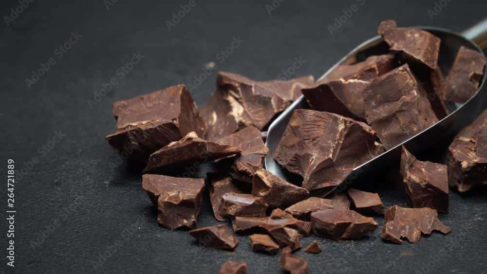 Dark Chocolate chunks in metal scoop on dark concrete background Dark Chocolate chunks in metal scoop on dark concrete background
