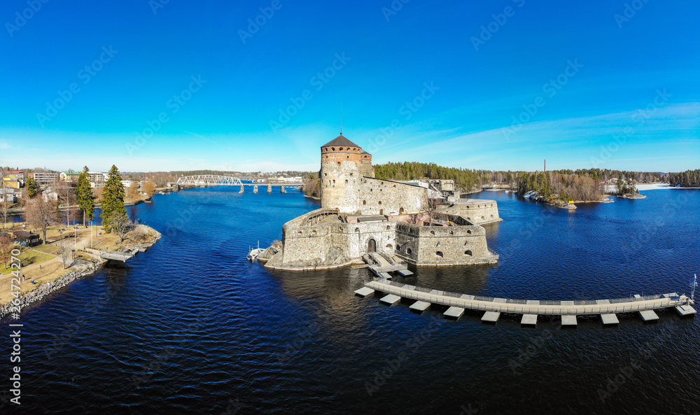 Beautiful aerial view of Olavinlinna, Olofsborg ancient fortress, the 15th-century medieval three - tower castle located in Savonlinna city on a sunny summer day, Finland. Shooting from a quadcopter.