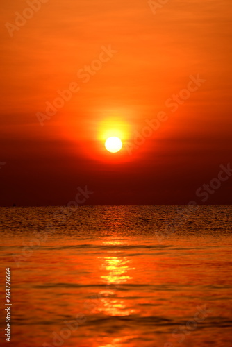 The rising sun view and the beach. Beautiful golden yellow sky and sun © tharathip