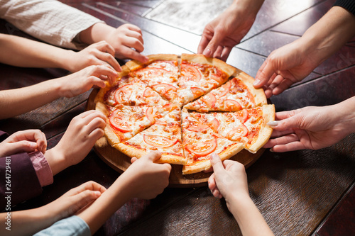 children eat pizza in a restaurant.